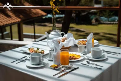 a table topped with plates of food and drinks at Hotel Villarma in Alis