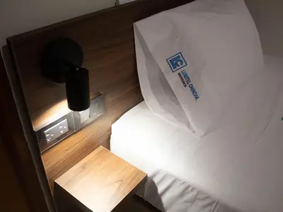 a bed with a paper bag on top of it at Luxotel Business Chincha in Chincha Alta