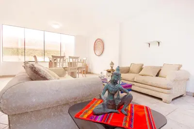 a living room with a couch and a statue on a table at Casa Las Brisas de Villa frente al mar in Lima