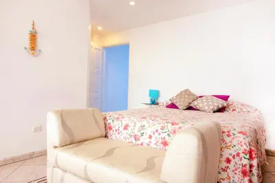 a bedroom with a bed and a couch at Casa Las Brisas de Villa frente al mar in Lima
