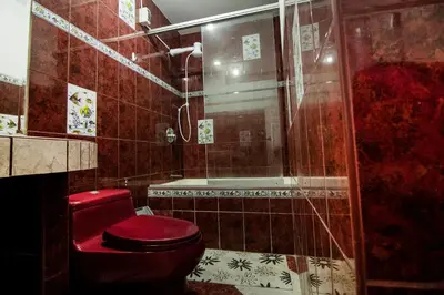 a bathroom with a red toilet and a shower at Casa Las Brisas de Villa frente al mar in Lima