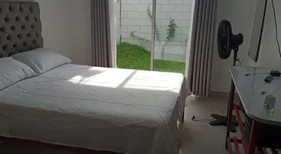 a bedroom with a bed and a desk and a window at Casa con piscina, terraza y parrilla en Ica in Ica