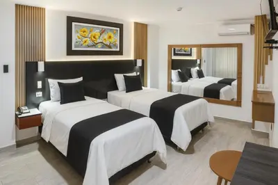 a hotel room with two beds and a mirror at City Tower Hotel in Lima