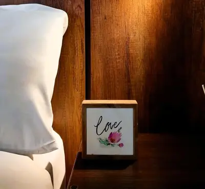 a box with the word love sitting on a table next to a bed at Loft steps away from Larcomar for urban explorers in Lima