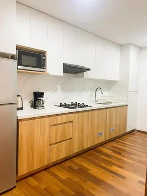 a kitchen with white cabinets and a sink and a refrigerator at Loft steps away from Larcomar for urban explorers in Lima
