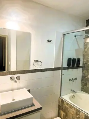 a bathroom with a sink and a glass shower at Loft steps away from Larcomar for urban explorers in Lima