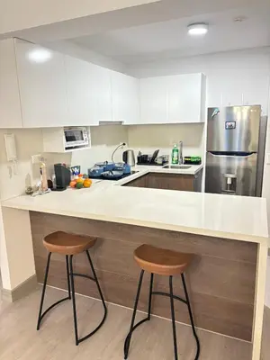 a kitchen with a counter and two stools in it at San Isidro Financial Flat Lima in Lima