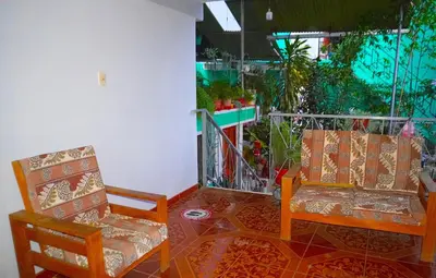 a room with two chairs and a window with plants at Cómodo alojamiento con jardín y baño privado-Echarati