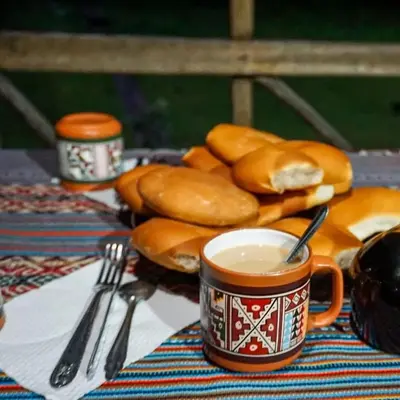 a table with a cup of coffee and some bagels at Yawar inka ayllu challhuay in Colcapampa