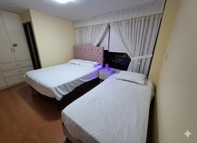 a bedroom with two beds and a window at Completo, Moderno y Confortable Departamento in Lima
