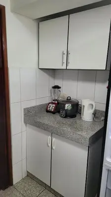a kitchen with white cabinets and a counter top at Completo, Moderno y Confortable Departamento in Lima