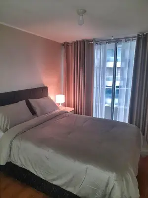 a bedroom with a large bed and a window at Departamento con Vista al Mar in Lima