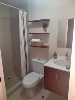 a bathroom with a toilet and a sink and a shower at Departamento con Vista al Mar in Lima