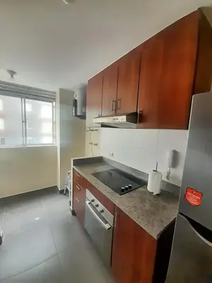 a kitchen with wooden cabinets and a stove top oven at Departamento con Vista al Mar in Lima