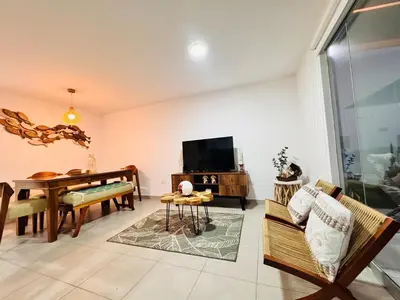 a living room with a dining table and a television at A unos pasos de la Arena in Puerto Viejo