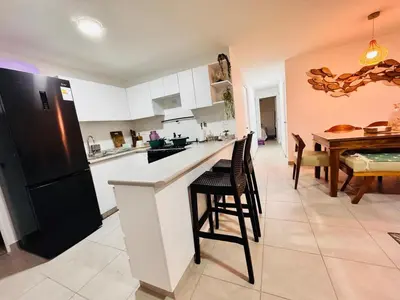 a kitchen with a black refrigerator and a table at A unos pasos de la Arena in Puerto Viejo