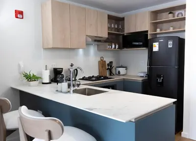 a kitchen with a sink and a black refrigerator at Estancia de lujo en Miraflores Entre Marriott y Pullman in Lima