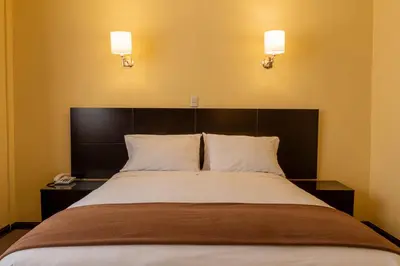 a bedroom with a large bed with two pillows at El Marquez Huancayo in Huancayo