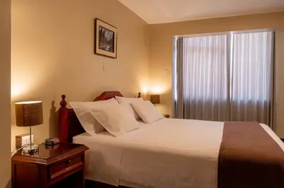 a bedroom with a large bed and a window at El Marquez Huancayo in Huancayo
