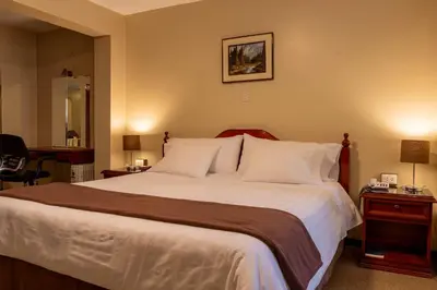 a bedroom with a large bed with white pillows at El Marquez Huancayo in Huancayo