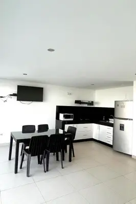 a kitchen with a table and chairs and a refrigerator at Departamento con Jacuzzi privado y acceso directo al mar in Asia
