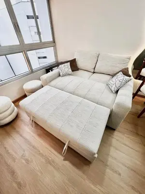 a living room with a white couch and a large window at Depa moderno y ejecutivo en estreno, cerca de San Isidro y Miraflores - nómada in Lima
