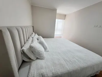 a bedroom with a bed with white sheets and pillows at Depa moderno y ejecutivo en estreno, cerca de San Isidro y Miraflores - nómada in Lima