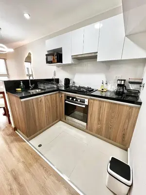a kitchen with white cabinets and black counter tops at Depa moderno y ejecutivo en estreno, cerca de San Isidro y Miraflores - nómada in Lima