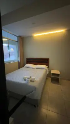 a bedroom with a bed with two cups on it at Hotel Rodilla in Ayacucho