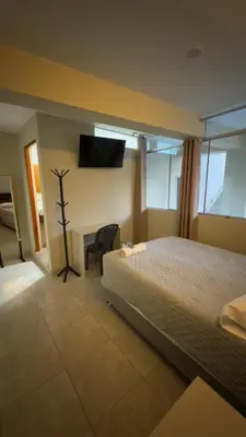 a bedroom with a bed and a desk and a television at Hotel Rodilla in Ayacucho