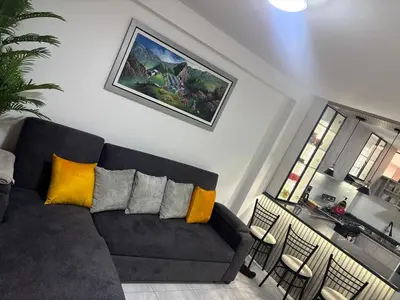 a living room with a black couch with yellow pillows at Mini Departamento in Lima