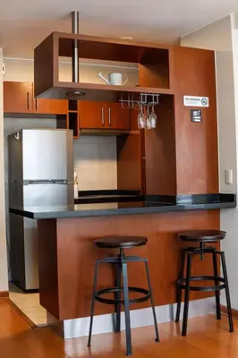 a kitchen with a counter and two bar stools at Departamento Athelier in Lima