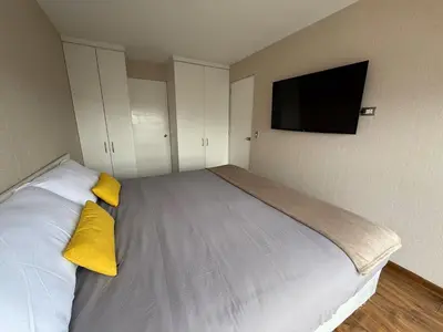 a bedroom with a bed with yellow pillows and a flat screen tv at Departamento Lock in Lima