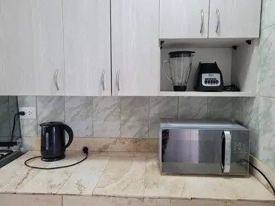 a kitchen with a microwave and a blender on the counter at Casa con Piscina privada y a pasos de la playa in Lurín