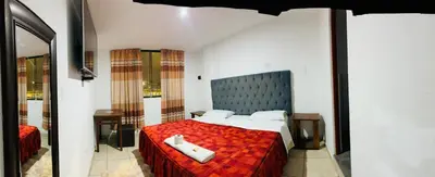 a bedroom with a large bed with a red blanket at Hotel World Peru in Lima