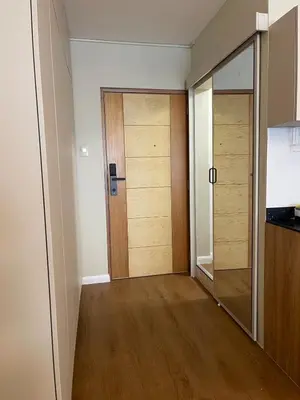 a hallway with two wooden doors and a mirror at Mini Apartment Ares 2 in Lima