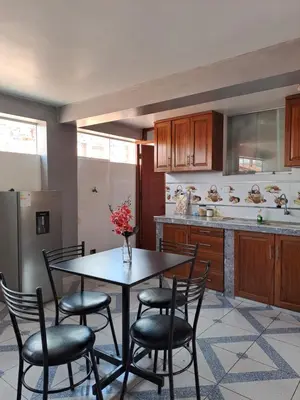 a kitchen with a table and chairs and a refrigerator at Nina's House in Cusco