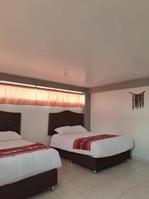 a bedroom with two beds and a window at Nina's House in Cusco