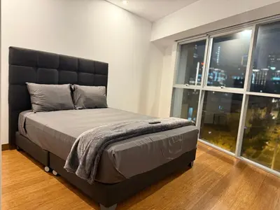 a bedroom with a large bed with a large window at Luxloft in Lima