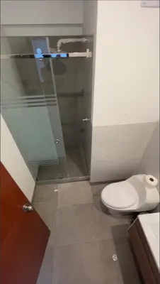 a bathroom with a toilet and a glass shower at Luxloft in Lima