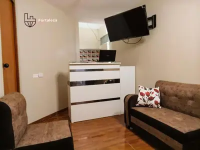 a living room with a tv and a couch at Hotel Fortaleza in Chasquitambo