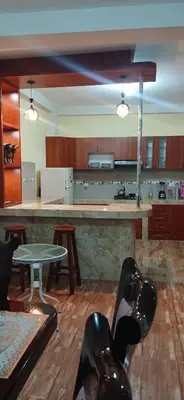 a kitchen with a large counter and a table at Habitación triple in Huayllabamba
