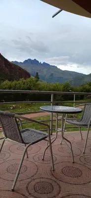 a picnic table and two chairs on a patio at Habitación triple in Huayllabamba