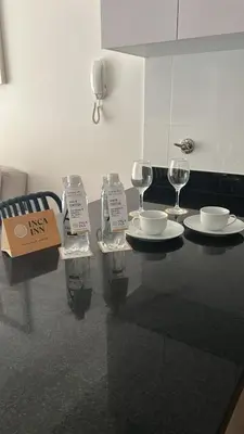 a table with two plates and wine glasses on it at Patria Inca Inn in Lima