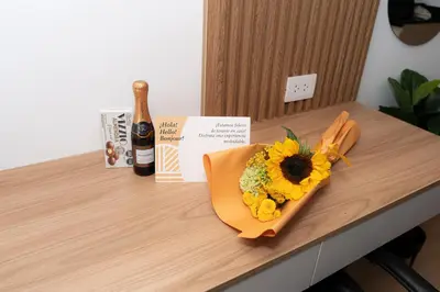 a bouquet of flowers on a table with a bottle of wine at Patria Inca Inn in Lima