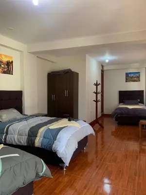 a bedroom with two beds and a dresser at Habitación simple triple in Huayllabamba