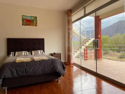 a bedroom with a bed and a sliding glass door at Habitación matrimonial con jacuzzi in Huayllabamba