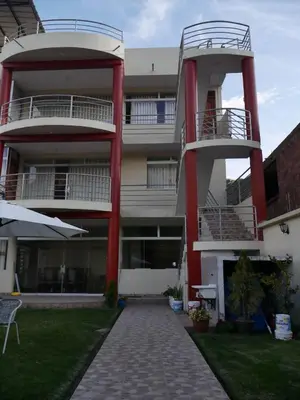 an apartment building with two balconies and a patio at Habitación matrimonial con jacuzzi in Huayllabamba
