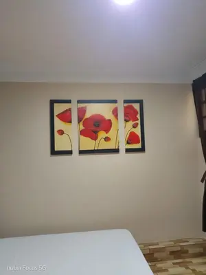 three paintings on a white wall in a bedroom at Hospedaje el señorial in Lima