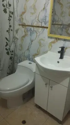 a bathroom with a toilet and a sink and a mirror at Hospedaje el señorial in Lima